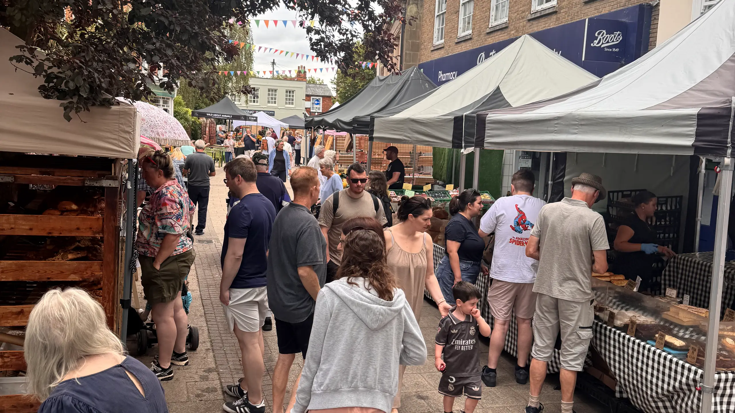 Shoppers browsing stalls along a busy lane at Beccles Sunday Market