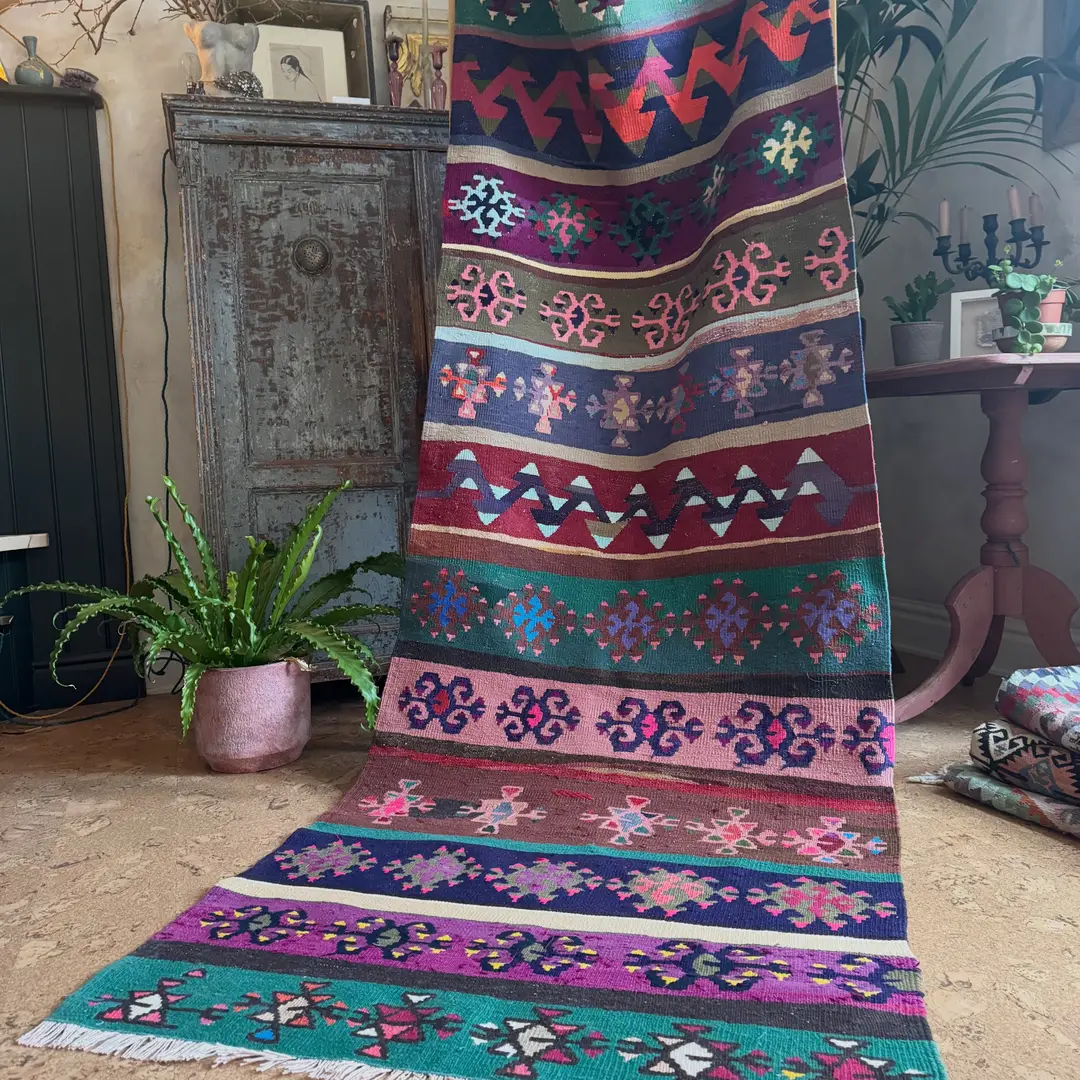Stacked handwoven kilim rugs on a market stall