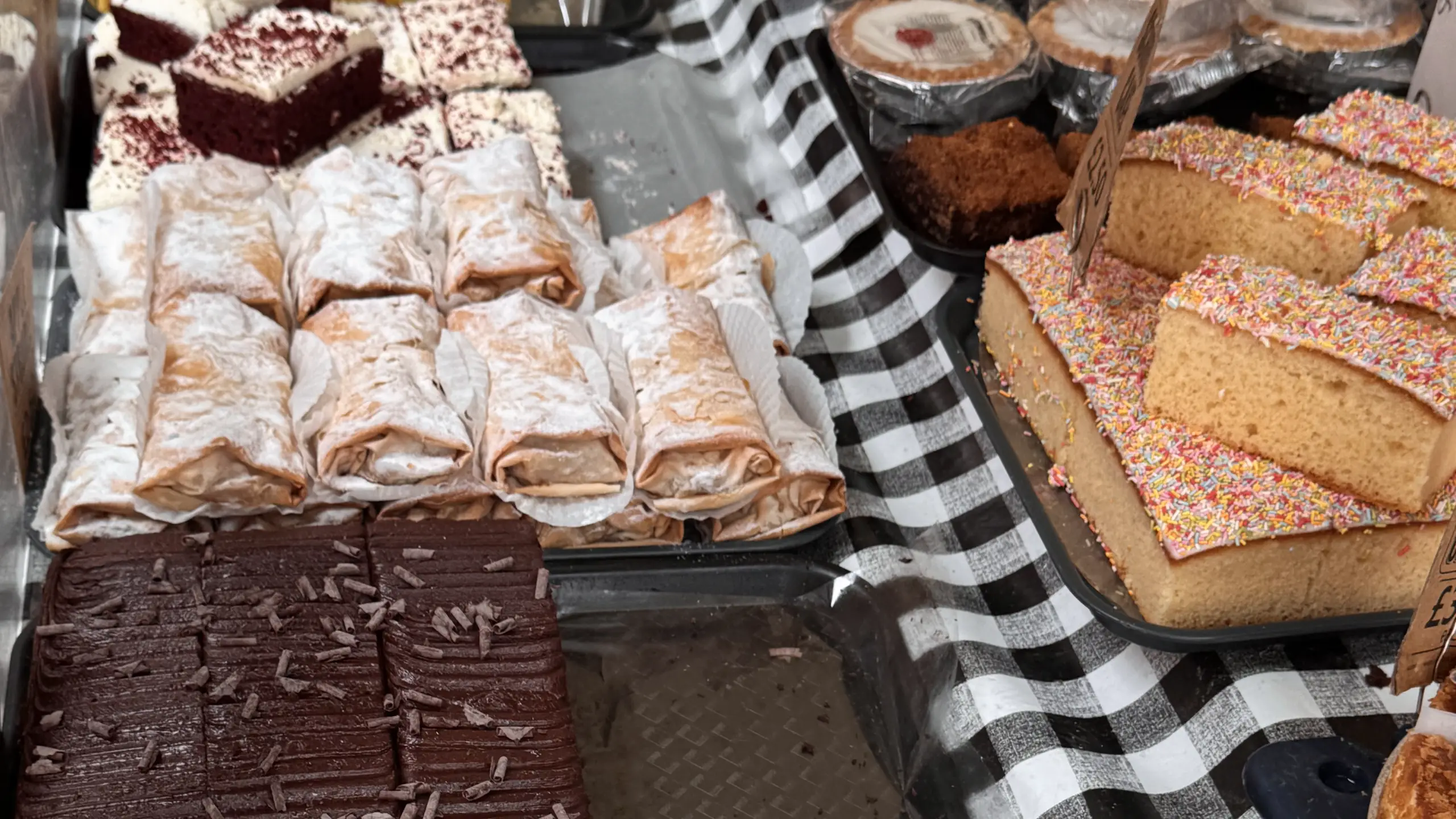 A table of homemade cakes, brownies and traybakes at a market stall