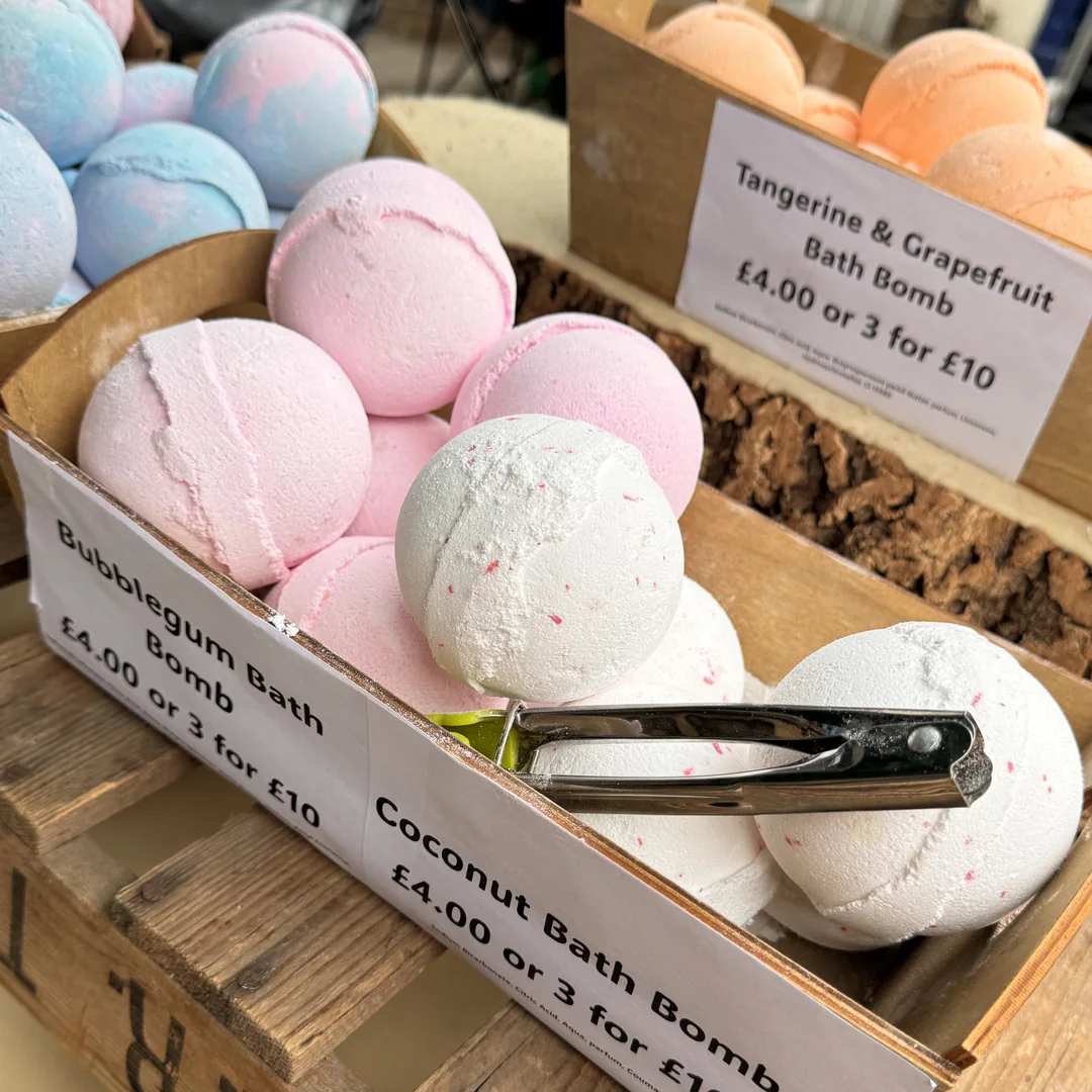 Crates of handmade bath bombs with handwritten price cards on a stall at Beccles Sunday Market