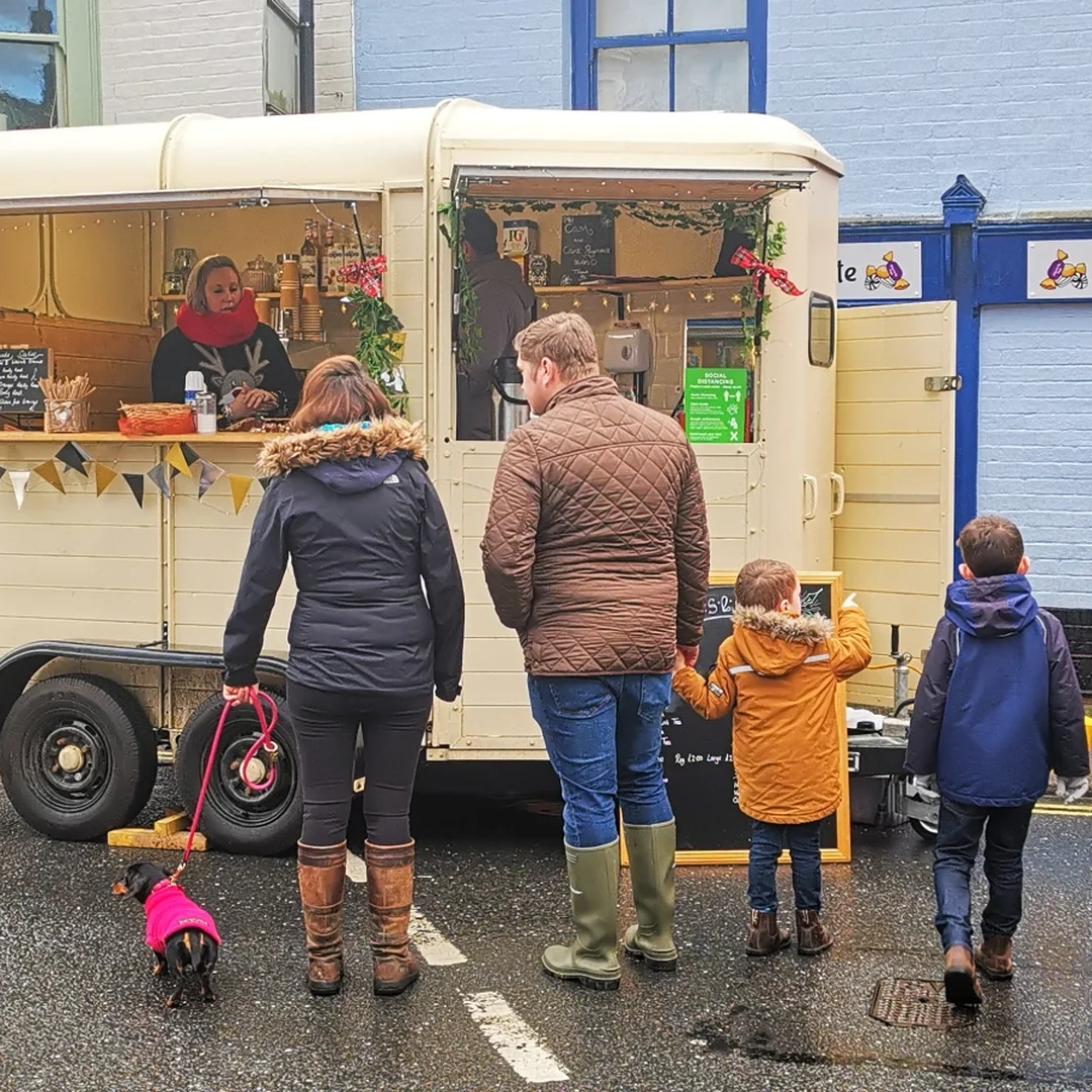 A family queuing at a food trailer on the street at Beccles Sunday Market