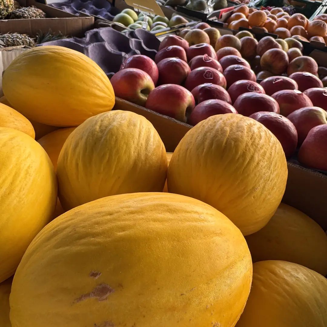 Melons and apples on a fresh fruit and vegetable stall at Beccles Sunday Market