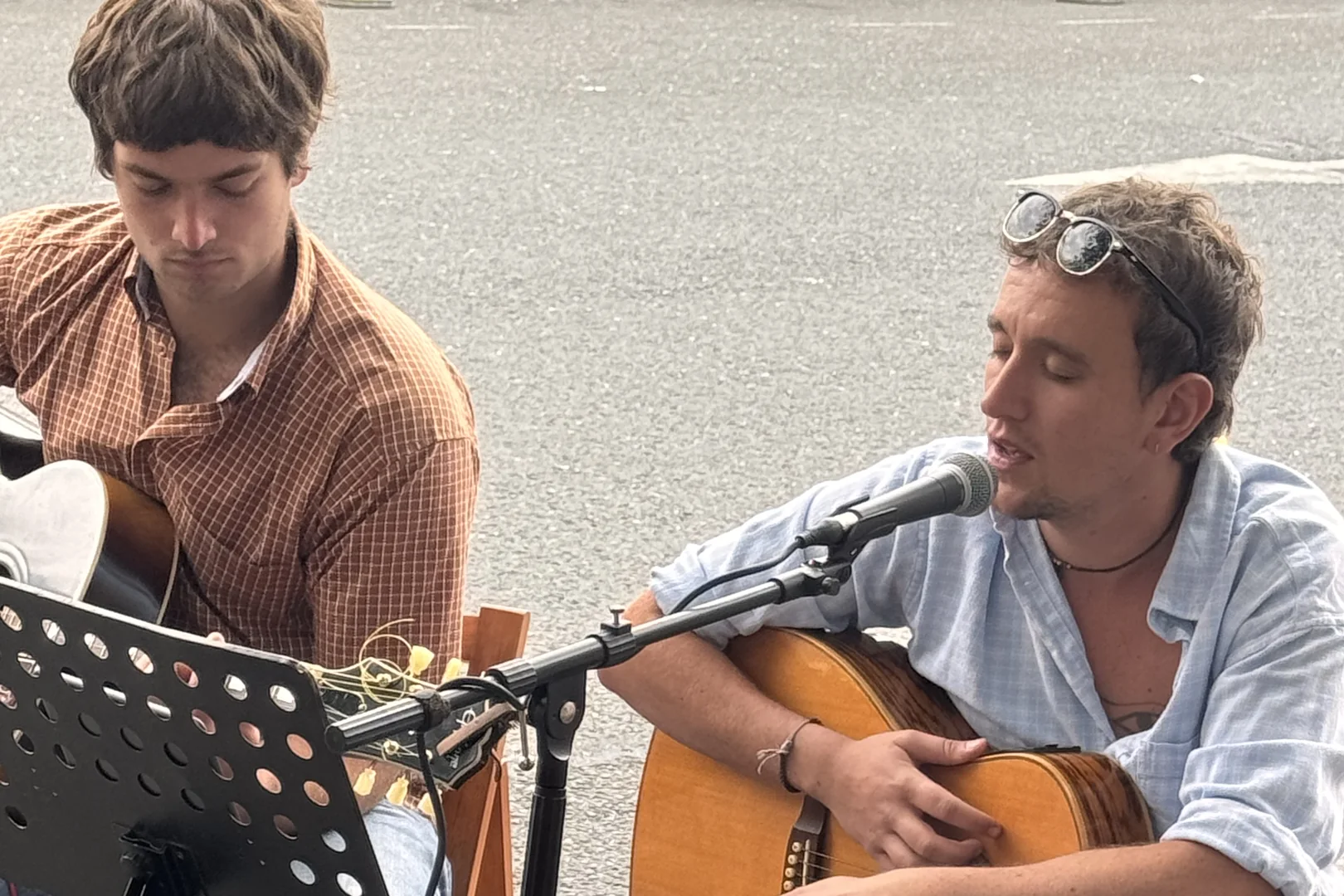 Two musicians playing guitar and singing in the street at Beccles Sunday Market